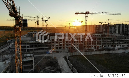 Silhouettes of construction cranes at sunset. Drone video. Silhouettes of construction cranes at sunset. Drone video. 81392182