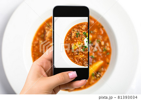Smartphone camera hand point shoot photo soup. Food photograph. Made for social networks. 81393034
