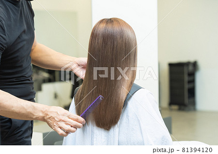 ヘアサロンで髪の毛をセットするスタイリスト ヘアサロンで髪の毛をセットするスタイリスト 81394120