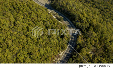 Aerial above view of a rural landscape with a curvy road running through it in Russia. Drone photography. Aerial above view of a rural landscape with a curvy road running through it in Russia. Drone photography. 81396015
