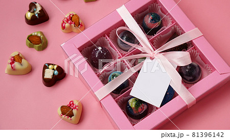 Chocolate candy. Pink gift box with handmade chocolates on pink 81396142