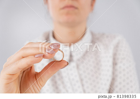 Faceless caucasian woman holding a wedding ring. Faceless caucasian woman holding a wedding ring. 81398335