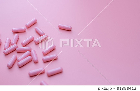 Pink capsules pill spread on pink background. Vitamin and supplement for healthy skin and acne concept. Online pharmacy. Pharmacy store banner. Pharmaceutical industry. Love treatment recipe. 81398412