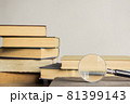 Open book and a magnifying glass over the light wall. 81399143
