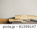 Open book and a magnifying glass over the light wall. 81399147