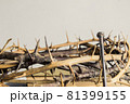 A thorn crown with nail on a wooden table.  81399155