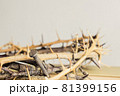 A thorn crown with nail on a wooden table.  81399156