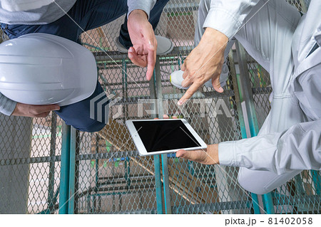 一戸建ての建築現場 2階の足場からタブレットを見て確認する男性2人の手元のアップ 一戸建ての建築現場 2階の足場からタブレットを見て確認する男性2人の手元のアップ 81402058
