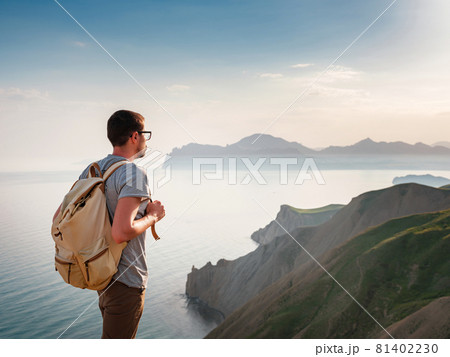 Young man travels alone on the backdrop of the mountains 81402230
