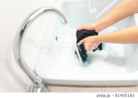 Female hands washing black color clothes in laundry sink Female hands washing black color clothes in laundry sink 81405183
