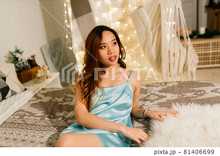 Beautiful young asian woman celebrating christmas at home, having fun while opening presents Beautiful young asian woman celebrating christmas at home, having fun while opening presents 81406699