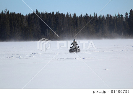 Quading Across a Windy Lake In Winter 81406735