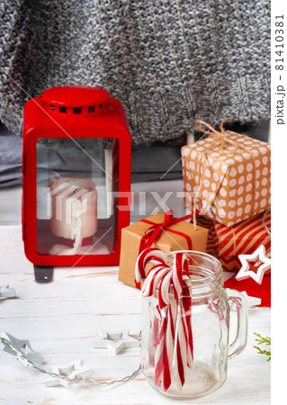 Pile of candy canes on table with red lantern 81410381