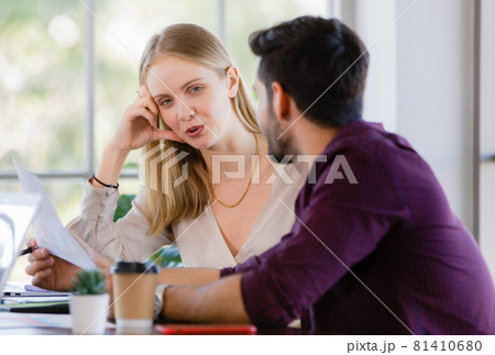 Two businesspeople, man and woman, working together in a modern office in an intimate manner. Idea for teamwork and good business colleagues Two businesspeople, man and woman, working together in a modern office in an intimate manner. Idea for teamwork and good business colleagues 81410680