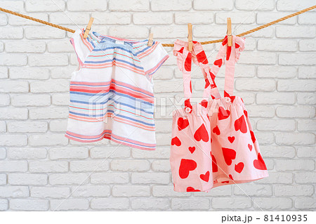 Washing of baby clothes pinned on a rope to dry Washing of baby clothes pinned on a rope to dry 81410935