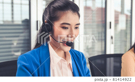 Businesswoman wearing headset working actively in office Businesswoman wearing headset working actively in office 81414922