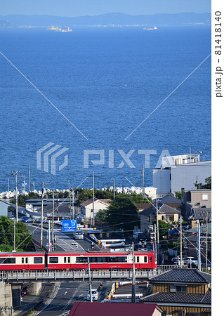 東京湾をバックに県道横須賀葉山線の道路とクロスする京急2100形電車 81418140