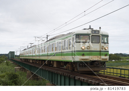 曇り空の分水橋梁を渡る越後線115系電車 81419783