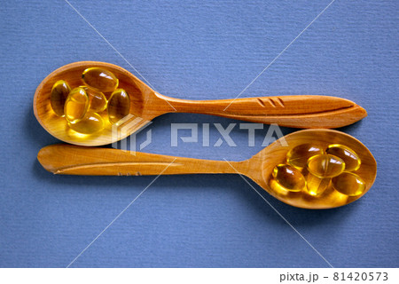 Medical concept. Wooden spoons with pills isolated on beautiful blue background. Web banner with a copy space. 81420573