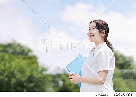 青空背景で笑顔で立つ女性看護師 81420732