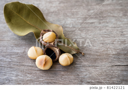 Peeled Macadamia nuts with leaf on wooden table 81422121