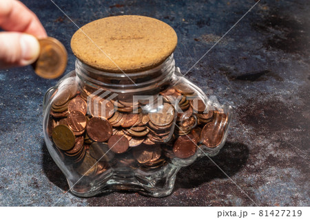 Large glass piggy bank full of copper coins Large glass piggy bank full of copper coins 81427219