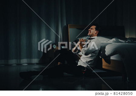 A young man in casual business clothes holding a pistol close eyes and aim at his chin to kill himself or commit suicide. Concept of hopelessness and give up people 81428050
