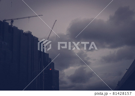 Unfinished huge building stop continues to construct at the time of depression economy. Concept of bankrupt and money problems construction business with dark grey clouds and sky in background 81428157