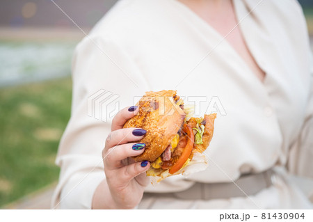 Close-up of a woman eating a burger. Bad eating habits 81430904