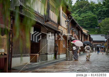 雨のひがし茶屋街を着物を着た女性が傘をさして歩く 81432650