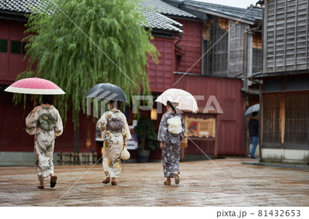 雨のひがし茶屋街を着物を着た女性が傘をさして歩く 81432653