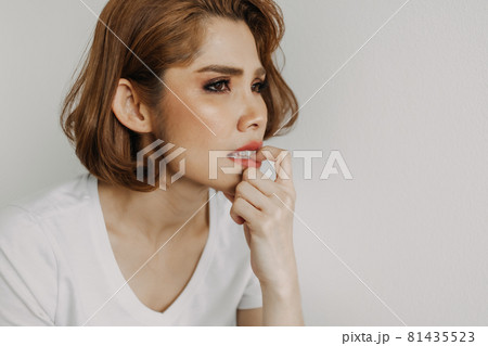 Woman is biting her nails alone in her apartment. 81435523