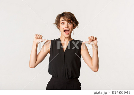Surprised and happy beautiful girl looking amazed as pointing at herself, white background Surprised and happy beautiful girl looking amazed as pointing at herself, white background 81436945