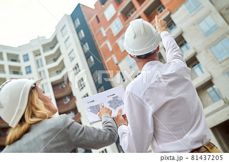 Two Caucasian colleagues inspecting together a construction object 81437205