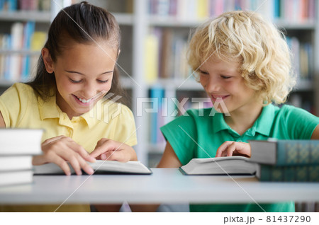 Two joyful classmates studying together at a public library Two joyful classmates studying together at a public library 81437290
