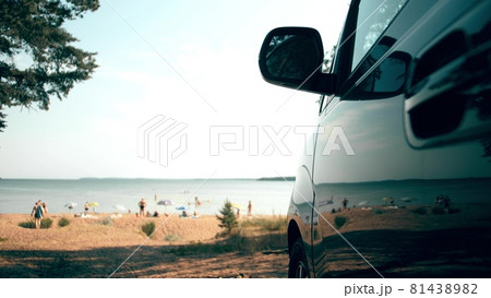 Parked van reflects sunbathing and swimming people on the beach. Summer vacations travel time 81438982