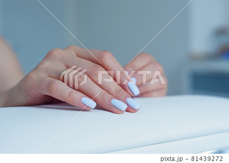 Beautiful female hands with a gentle blue manicure on a stand at beauty salon. Beautiful female hands with a gentle blue manicure on a stand at beauty salon. 81439272