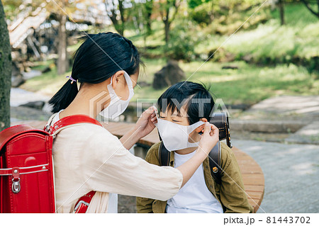 男の子にマスクをつけてあげる女の子 81443702