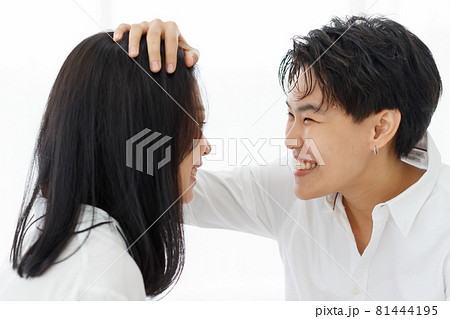 LGBTQ couple lovers, a handsome girl as man or butch and femme, spending and sharing loving time in white bedroom with fun, warmth, and happiness 81444195