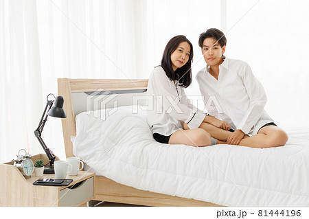 LGBTQ couple lovers, a handsome girl as man or butch and femme, spending and sharing loving time in white bedroom with fun, warmth, and happiness LGBTQ couple lovers, a handsome girl as man or butch and femme, spending and sharing loving time in white bedroom with fun, warmth, and happiness 81444196