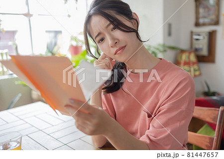 請求書を見て悩む若い女性 81447657