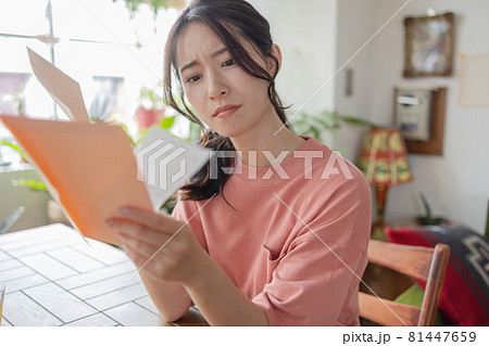 請求書を見て悩む若い女性 81447659
