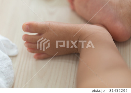 フローリングでお昼寝する赤ちゃんの足 81452295