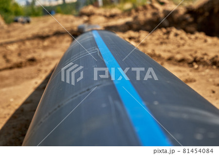 Large industrial black plastic polypropylene water pipe on the construction site for laying water pipes, construction and reconstruction of buildings and houses. Large industrial black plastic polypropylene water pipe on the construction site for laying water pipes, construction and reconstruction of buildings and houses. 81454084
