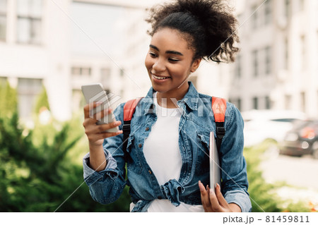 Happy Black College Girl Using Smartphone Texting Outdoor 81459811