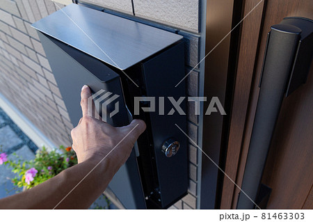 郵便ポストを開く男性の手元 郵便ポストを開く男性の手元 81463303