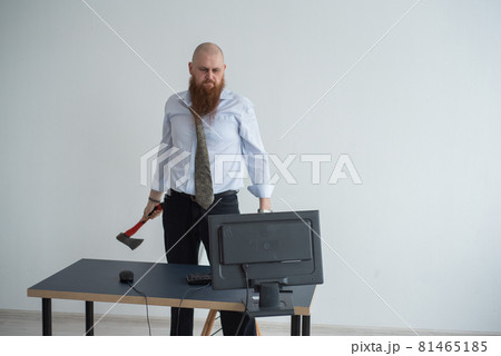 Stressed crazy businessman smashing his computer in office using ax problem concept. The man has problems at work and frustration. 81465185