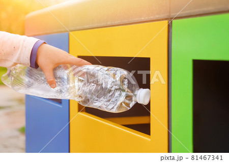 Garbage recycling plastic trash bins. Close up hand throwing plastic bottle recycling container garbage sorting rubbish collection bin. Hand kid put bottle plastic trash can. Reduce waste recycle bins 81467341
