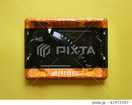 黄色い紙の中央に置いたプラスチックのスーパー弁当の空き容器 黄色い紙の中央に置いたプラスチックのスーパー弁当の空き容器 81472497