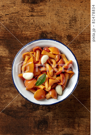 Pickled mushrooms with garlic and a bay leaf, shot from above 81478834